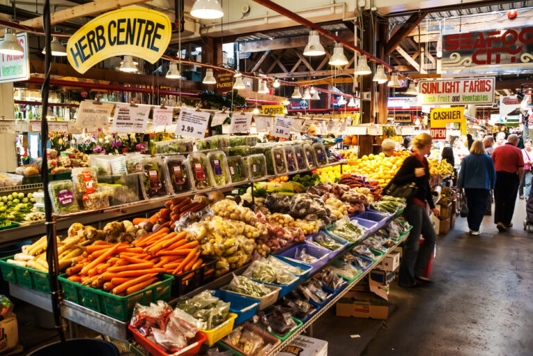 A woman is standing in front of an array of vegetables.