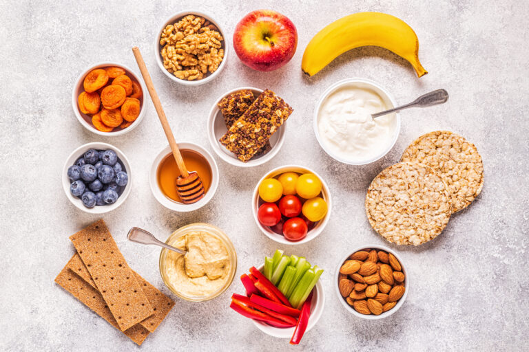 A table topped with bowls of food and crackers.